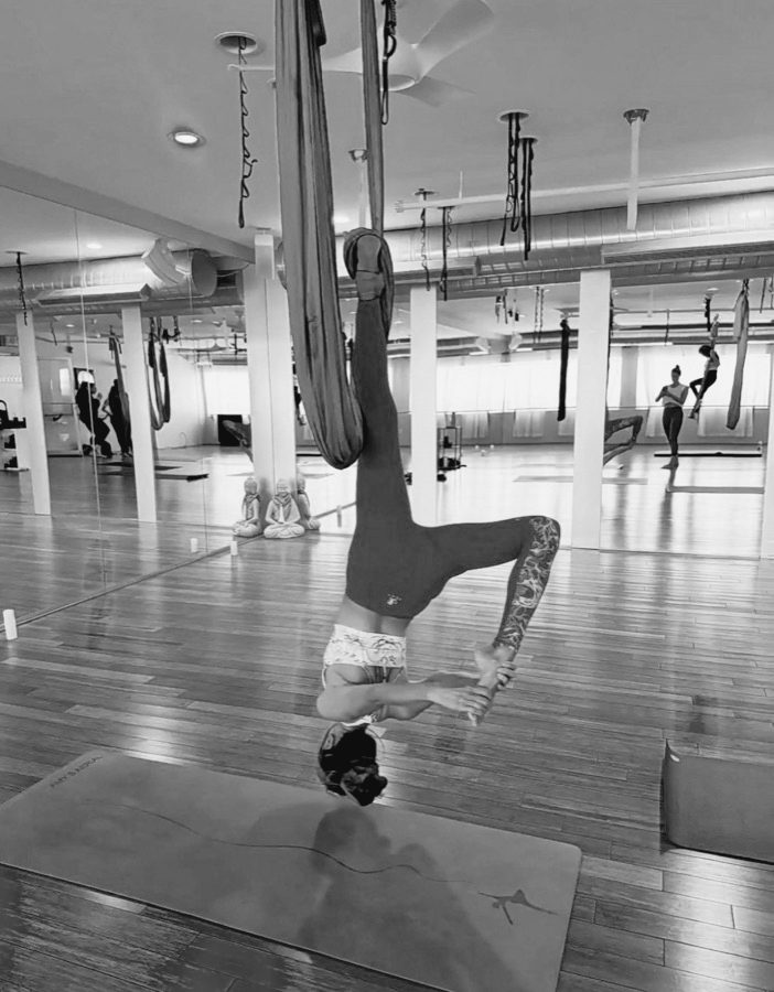 A student upside down in an aerial silk.